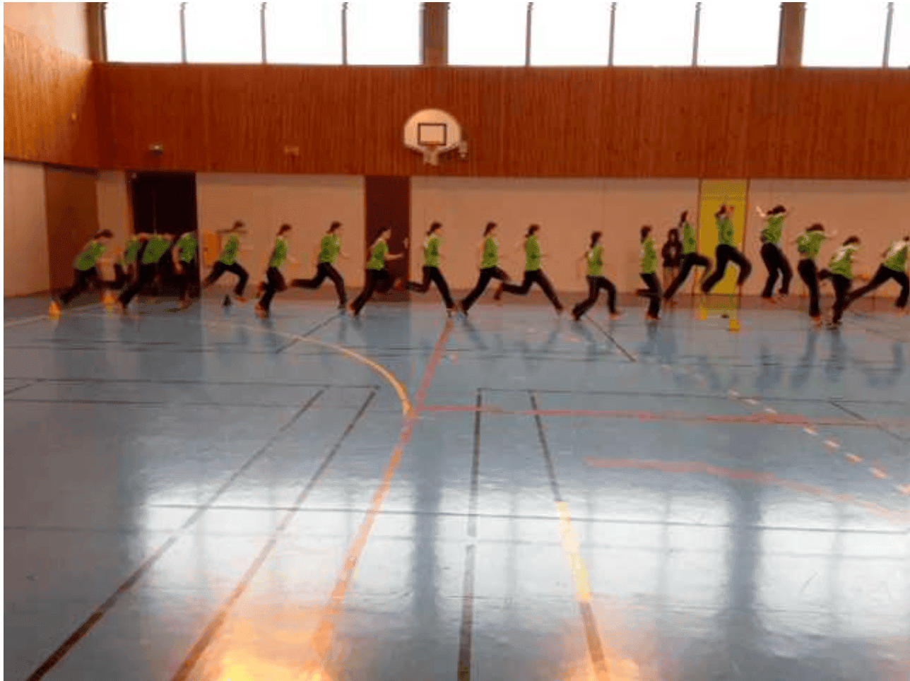 Chronophotographie d'une élève en pleine course dans un gymnase, positions superposées