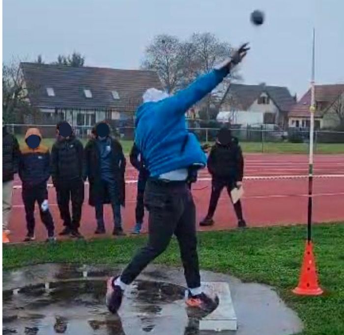 Élève réalisant un lancer de poids sur une piste d'athlétisme, filmé pour l'analyse cinématique