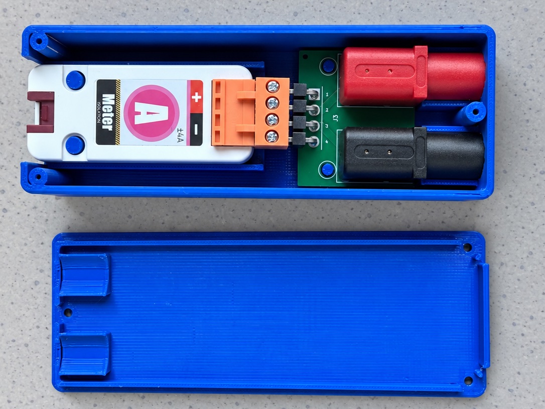 Module Ampèremètre M5Stack fixé par son bornier orange sur les broches du circuit à douilles, à l'intérieur du boîtier bleu