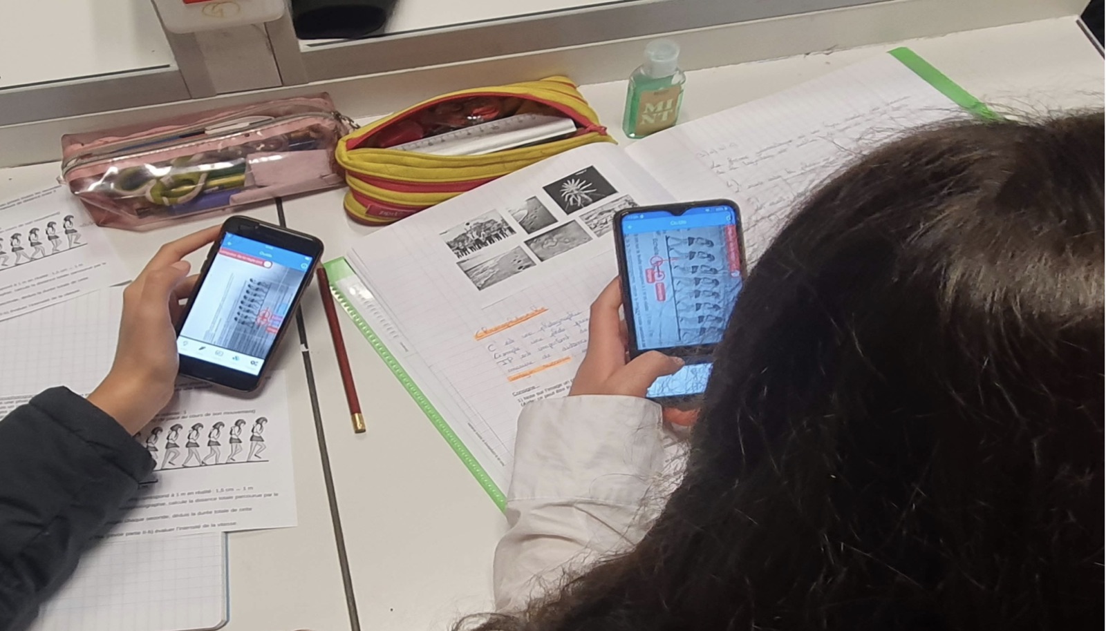 Deux élèves analysant une chronophotographie sur smartphone avec FizziQ en classe